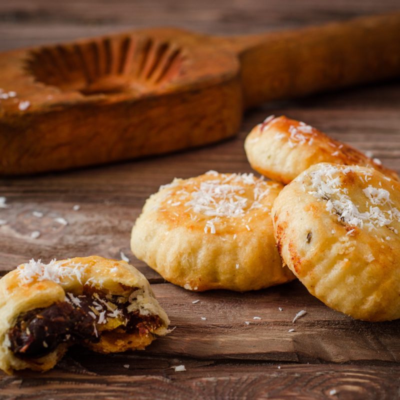 Maamoul or mamoul - arabic cookies stuffed dates with icing cugar on vintage wooden table background. Ramadan food